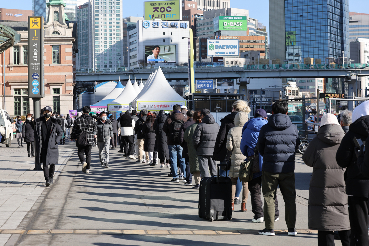 People line up to receive COVID-19 tests at a temporary testing center in Seoul on Friday. (Yonhap)