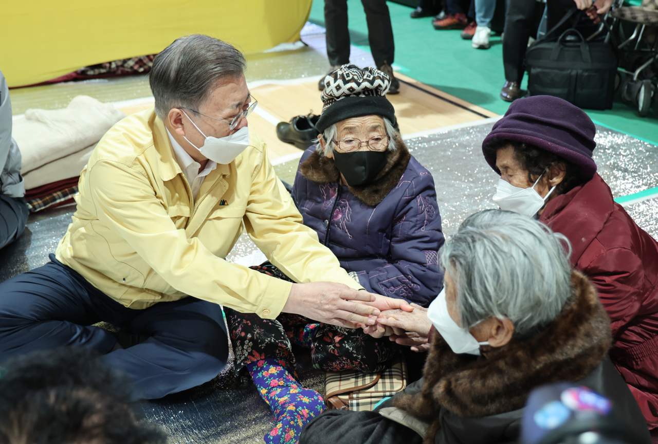 President Moon Jae-in (L) meets with victims of a wildfire in Uljin, 330 kilometers southeast of Seoul, at a makeshift shelter in the county on Sunday. (Yonhap)