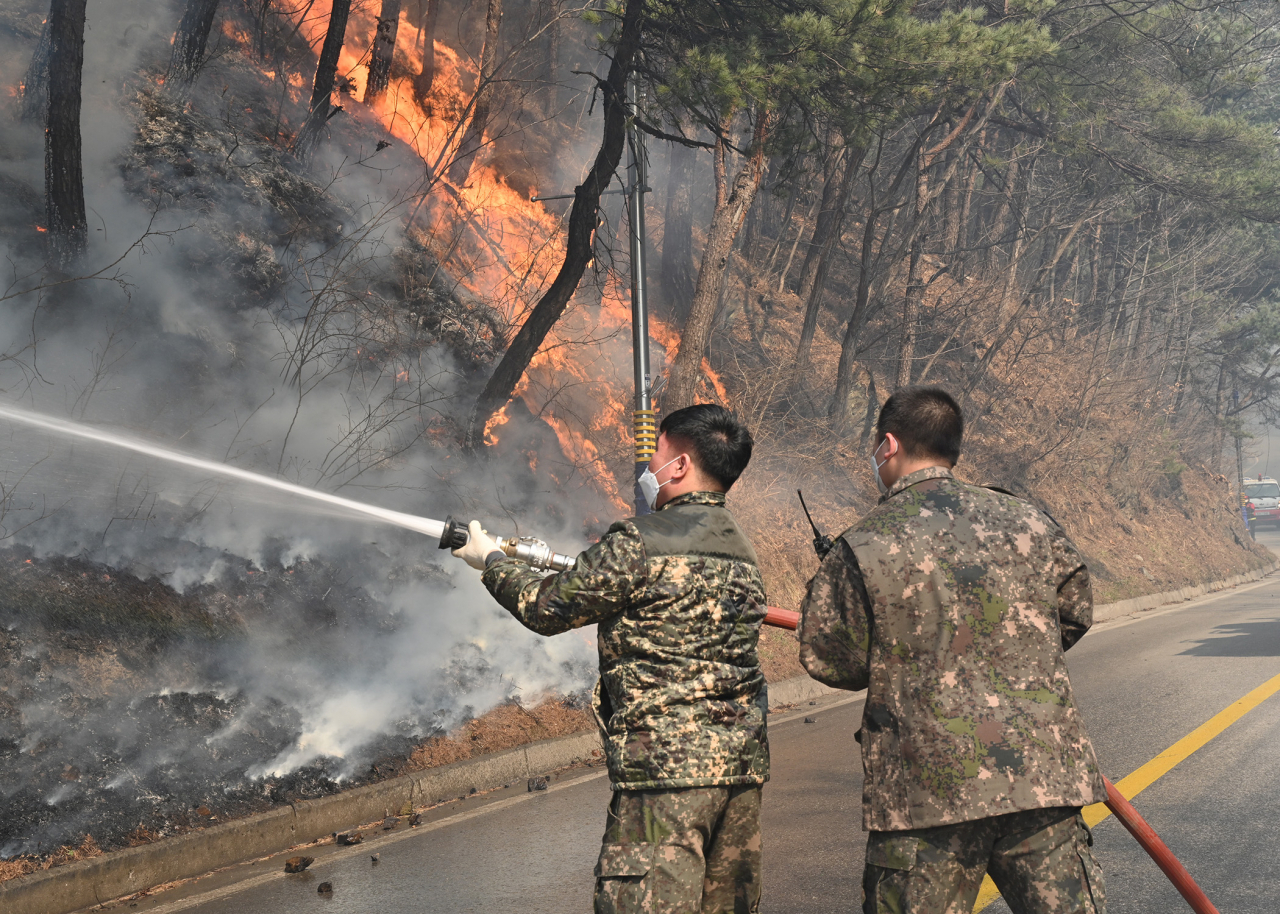 Service members put out a wildfire in Gangneung, 237 kilometers east of Seoul, last Saturday, in this photo released by the Air Force. (Air Force)