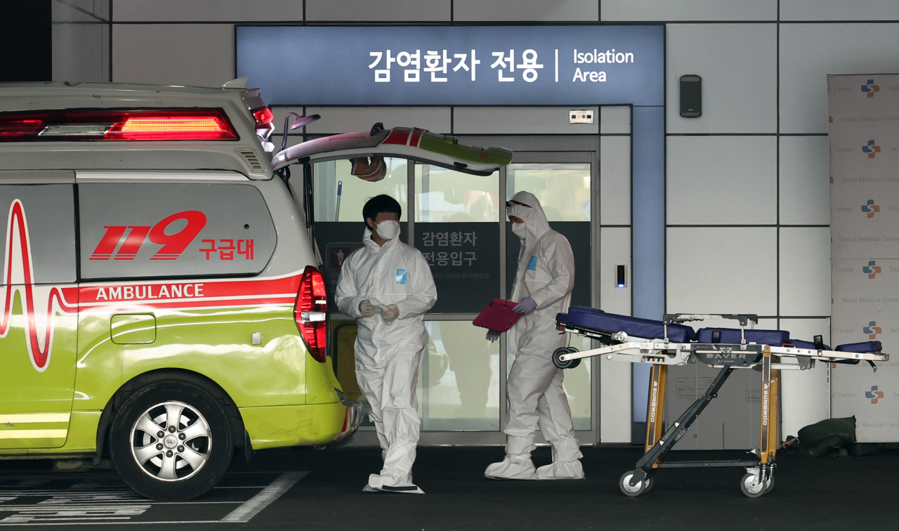 Health workers check equipment after transferring a COVID-19 patient to a local hospital, Monday. (Yonhap)