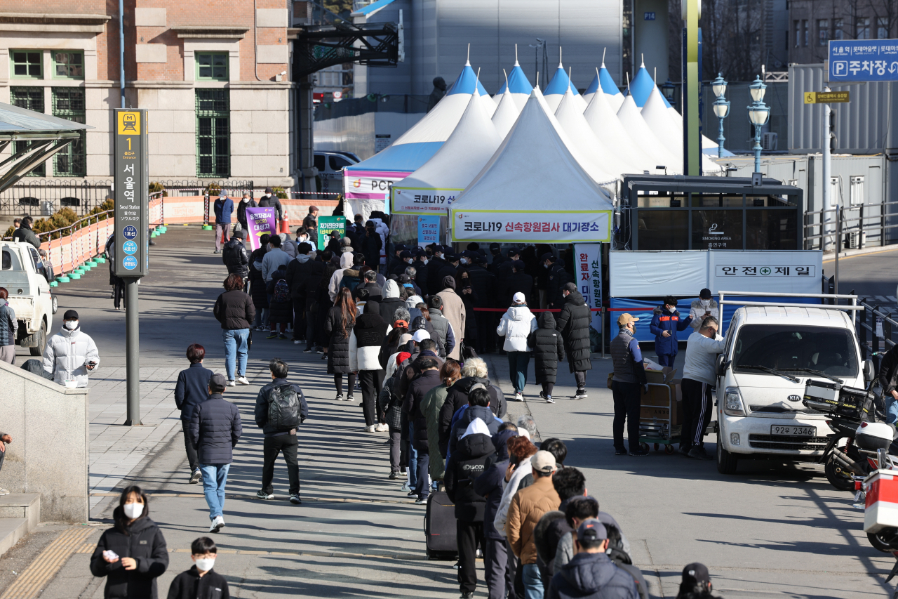 People wait in line to get tested for the coronavirus near a temporary testing center in front of Seoul Station in Seoul last Saturday. (Yonhap)