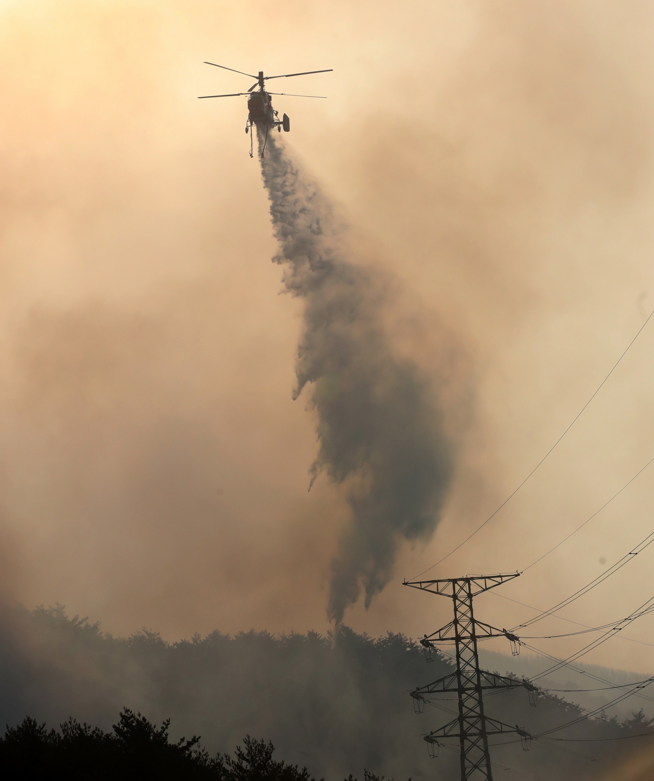 A Korea Forest Service helicopter participates in firefighting operations to put out a wildfire in Donghae, eastern South Korea, on Tuesday. (Yonhap)