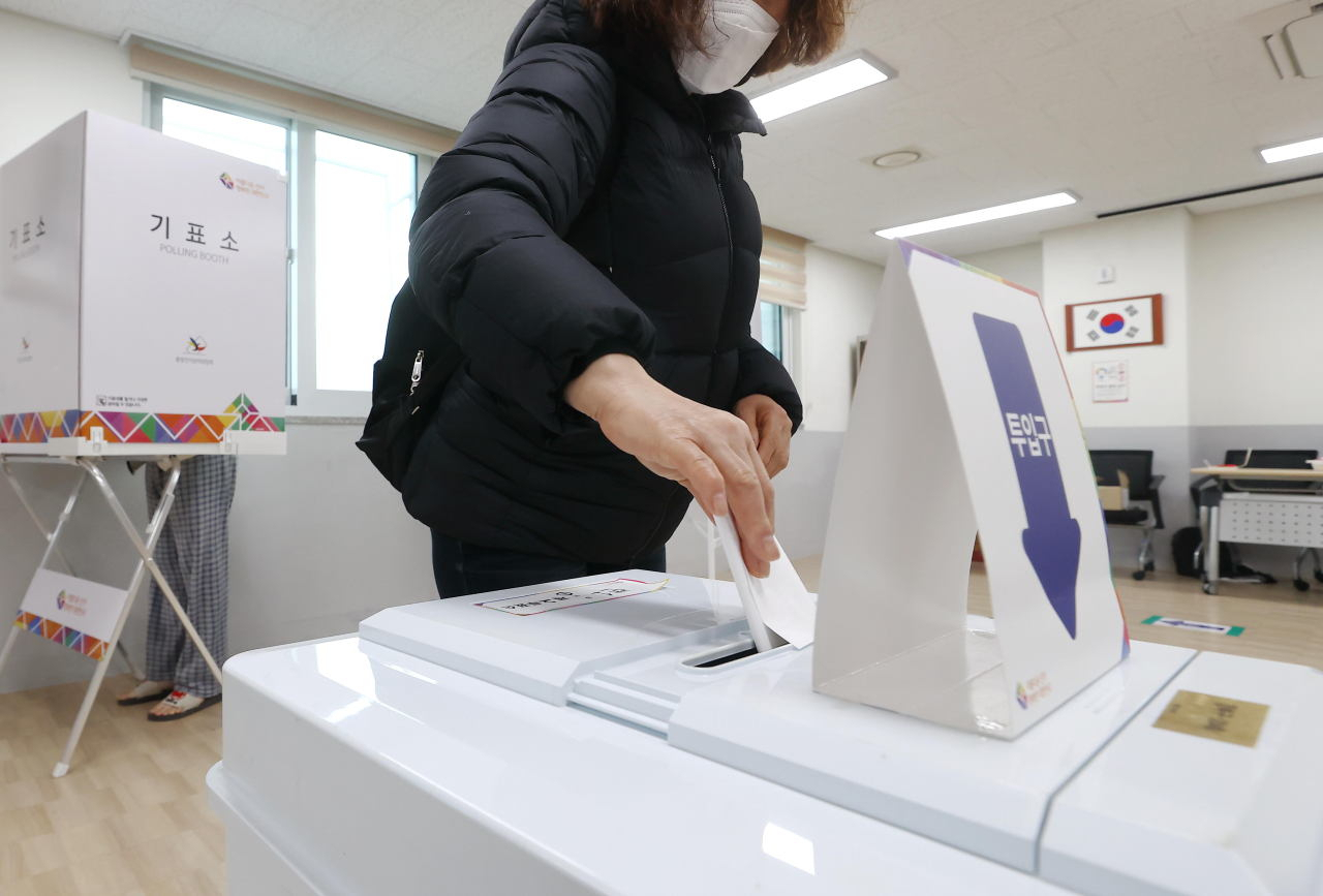 A voter puts her ballot in the voting box for South Korea`s 20th presidential election on Wednesday. (Yonhap)