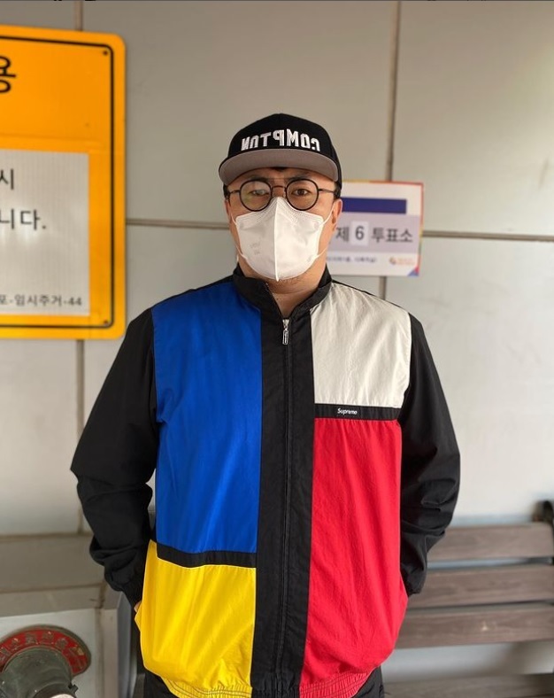 Defconn poses for a photo in front of a polling station. (Defconn’s Instagram)