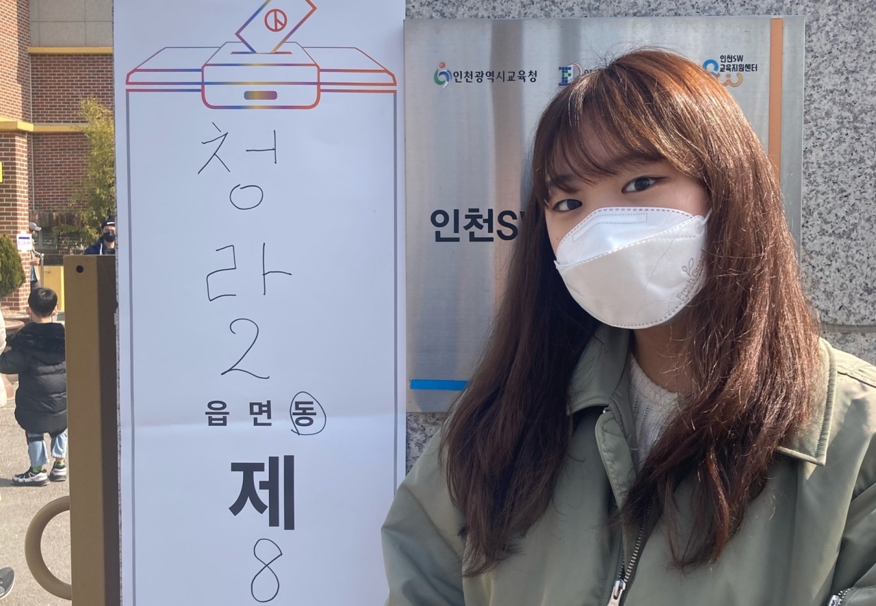Cho Hyeon-seo, 18, poses in front of a polling station sign in Incheon on Wednesday. (On courtesy of Cho)