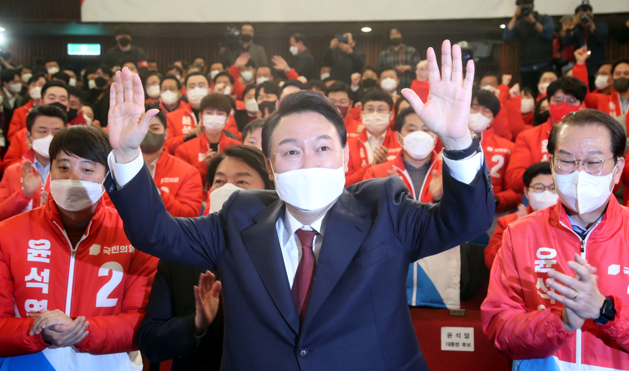 President-elect Yoon Suk-yeol holds his fists up in joy after confirming of his win in this year’s presidential election at the party’s campaign headquarter stationed at the National Assembly on Thursday. (Yonhap)