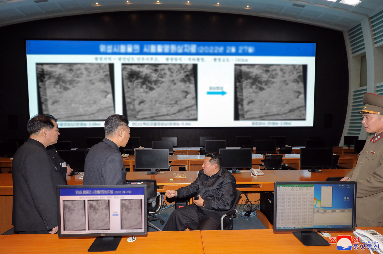 North Korea leader Kim Jong-un (C) speaks to officials during a visit to the National Aerospace Development Administration in this photo released by the North's official Korean Central News Agency on Thursday. (KCNA)