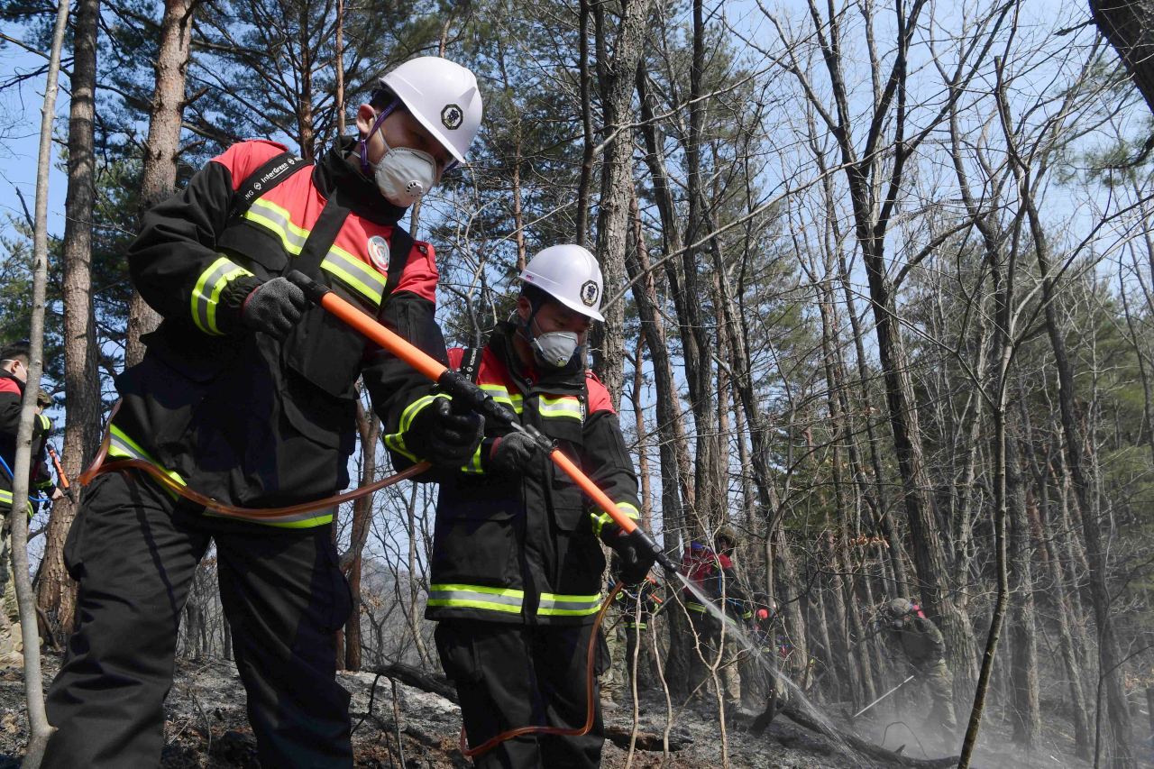 Soldiers from the Navy's First Fleet Command remove fire residue on a mountain in Donghae, 280 kilometers east of Seoul, on Tuesday, in this photo provided by the Navy. The country's eastern coastal areas have been heavily struck by wildfires amid strong winds since last Friday. (Navy)