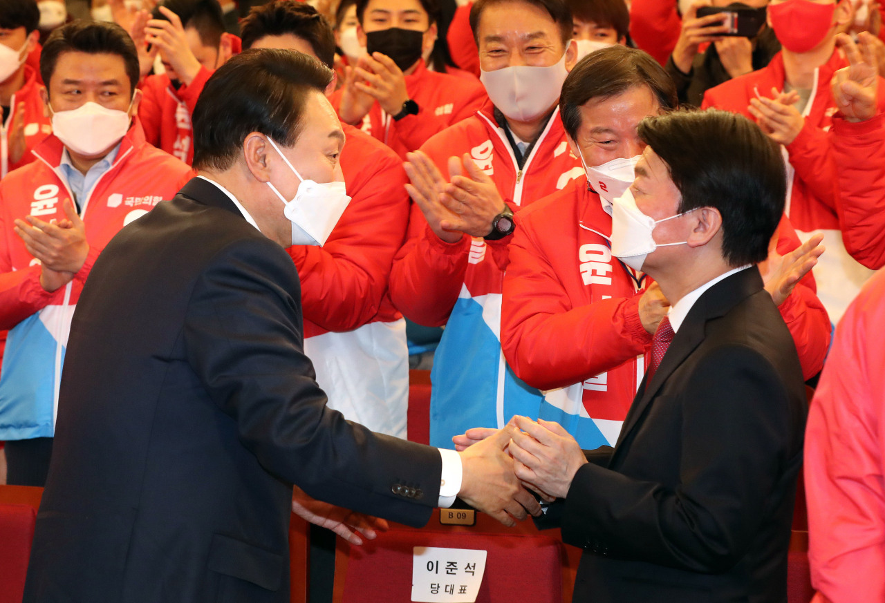 President-elect Yoon Suk-yeol greets People`s Party Chairman Ahn Cheol-soo at People Power Party`s situation room inside the National Assembly in Yeouido, western Seoul, on early Thursday morning. The two merged their candidacies in the 20th presidential election to help Yoon prevail by the end of the election. Ahn is widely touted as a pick to head Yoon`s Presidential Transition Committee. (Joint Press Corps)