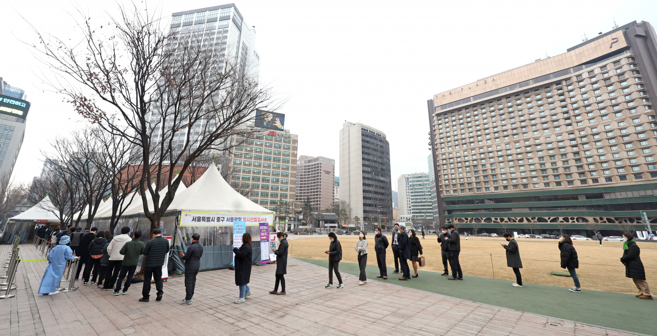 People wait in line to receive tests at a COVID-19 testing station in Seoul on Friday. (Yonhap)