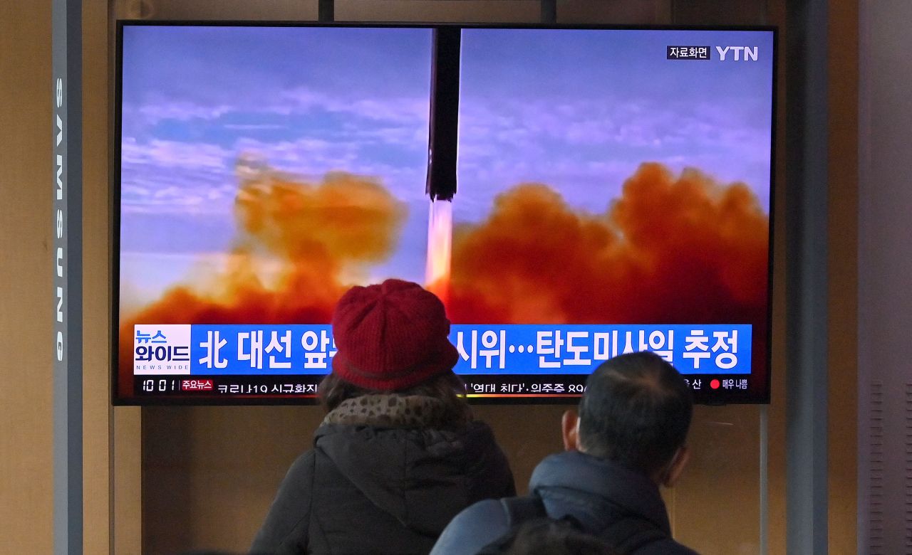 People watch a television screen showing a news broadcast with file footage of a North Korean missile test, at a railway station in Seoul on March 5, 2022, after North Korea fired at least one “unidentified projectile” in the country‘s ninth suspected weapons test this year according to the South’s military. (Yonhap)