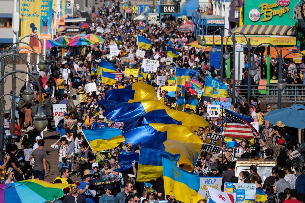 Demonstrators carrying a giant Ukrainian flag march during a rally in support of Ukraine in Santa Monica, California, on Saturday. (RINGO CHIU / AFP)