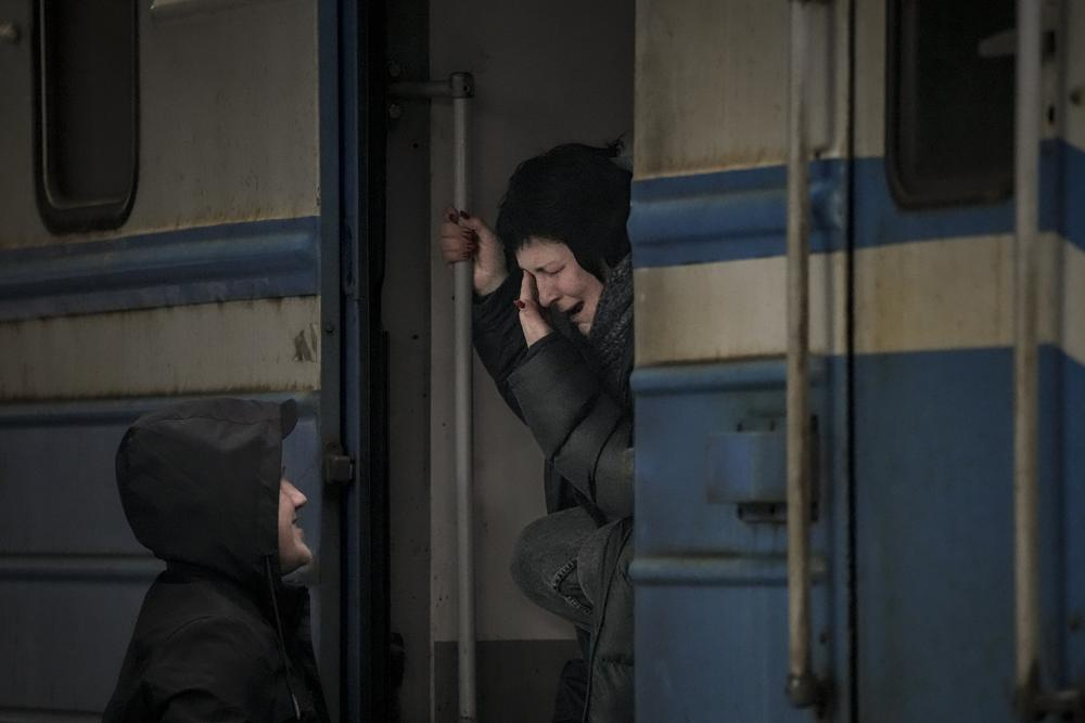 A woman on a Lviv bound train cries while she bids goodbye to a man in Kyiv, Ukraine on Saturday. Fighting raged in the outskirts of Ukraine's capital, Kyiv, and Russia kept up its bombardment of other resisting cities. (AP Photo/Vadim Ghirda)