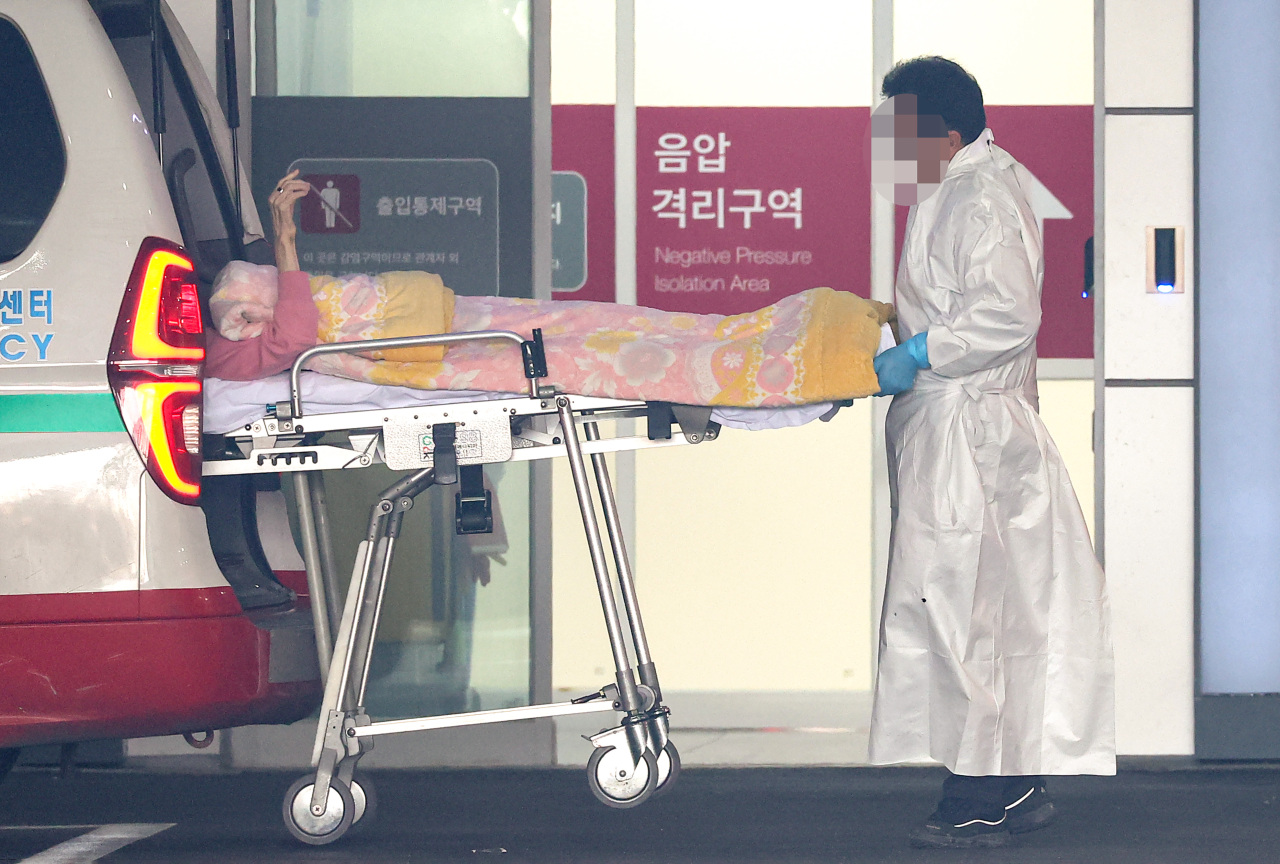 A patient on a stretcher is wheeled out of an ambulance at Seoul medical center on Tuesday. (Yonhap)
