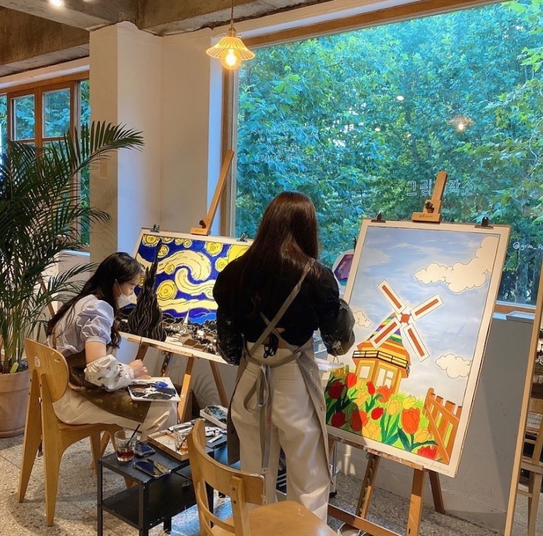 Visitors working on the art pieces at Grim Factory in Daehangno. (Grim Factory)