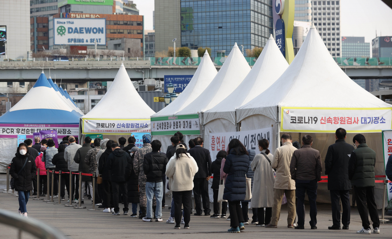 People line up for COVID-19 tests at a testing facility in central Seoul, Tuesday. (Yonhap)