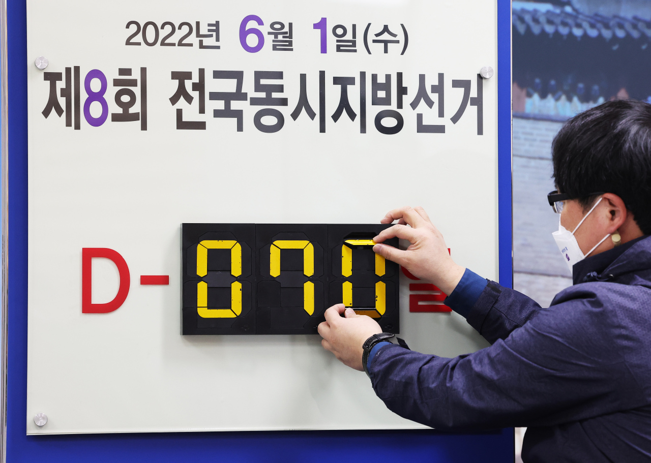 An official with the National Election Commission changes a sign made at the election watchdog`s office in Suwon, Gyeonggi Province, to mark that 70 days remain until the local elections in June.(Yonhap)
