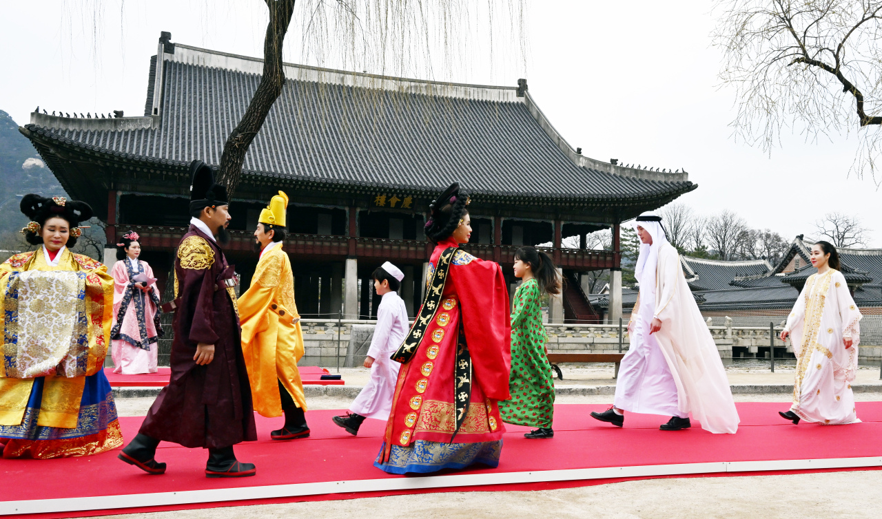 Models wearing royal court hanbok and traditional costumes of Qatar walk the runway at “The Hanbok” fashion show held Wednesday in front of Gyeonghoeru, a two-story pavilion structure located inside Gyeongbokgung, Jongno-gu, Seoul. (Park Hyun-koo/The Korea Herald)