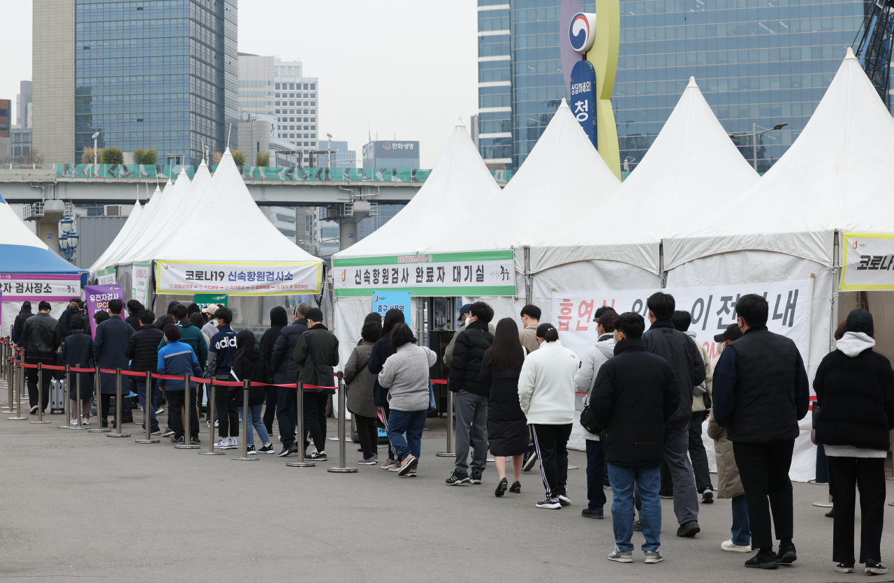 People line up for COVID-19 tests at a testing facility in central Seoul, Wednesday. (Yonhap)