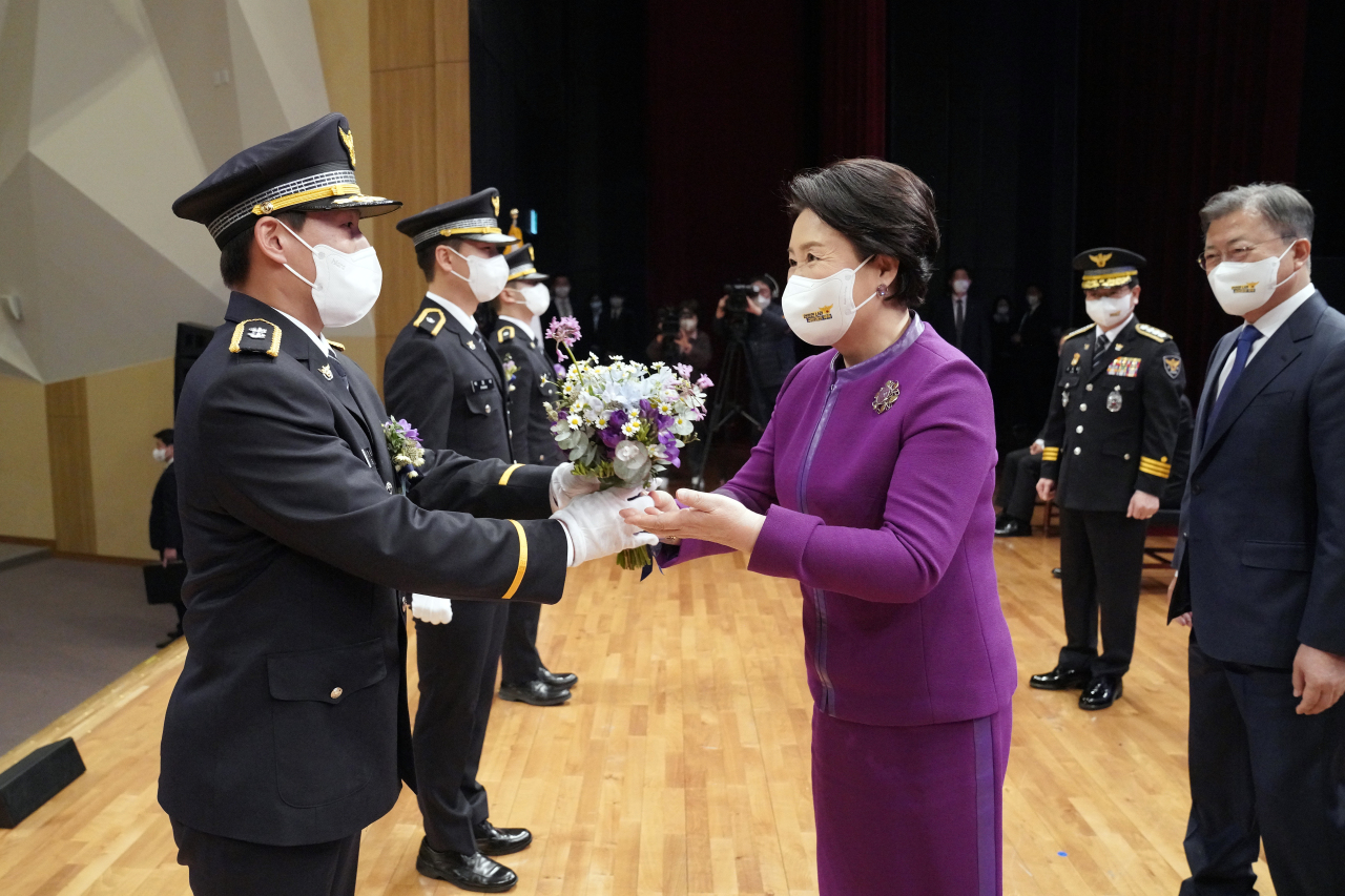 South Korea`s first lady Kim Jung-sook presents flowers new police appointees during a ceremony held in Asan, South Chungcheong Province, on March 17. (Cheong Wa Dae)