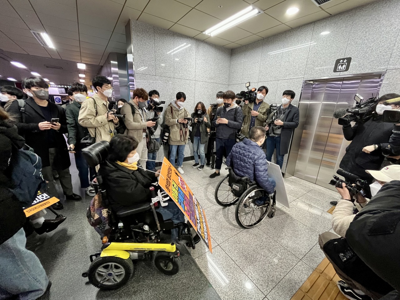 Protesters using wheelchairs wait in line for an elevator inside a subway station on Monday. (Kim Arin/The Korea Herald)