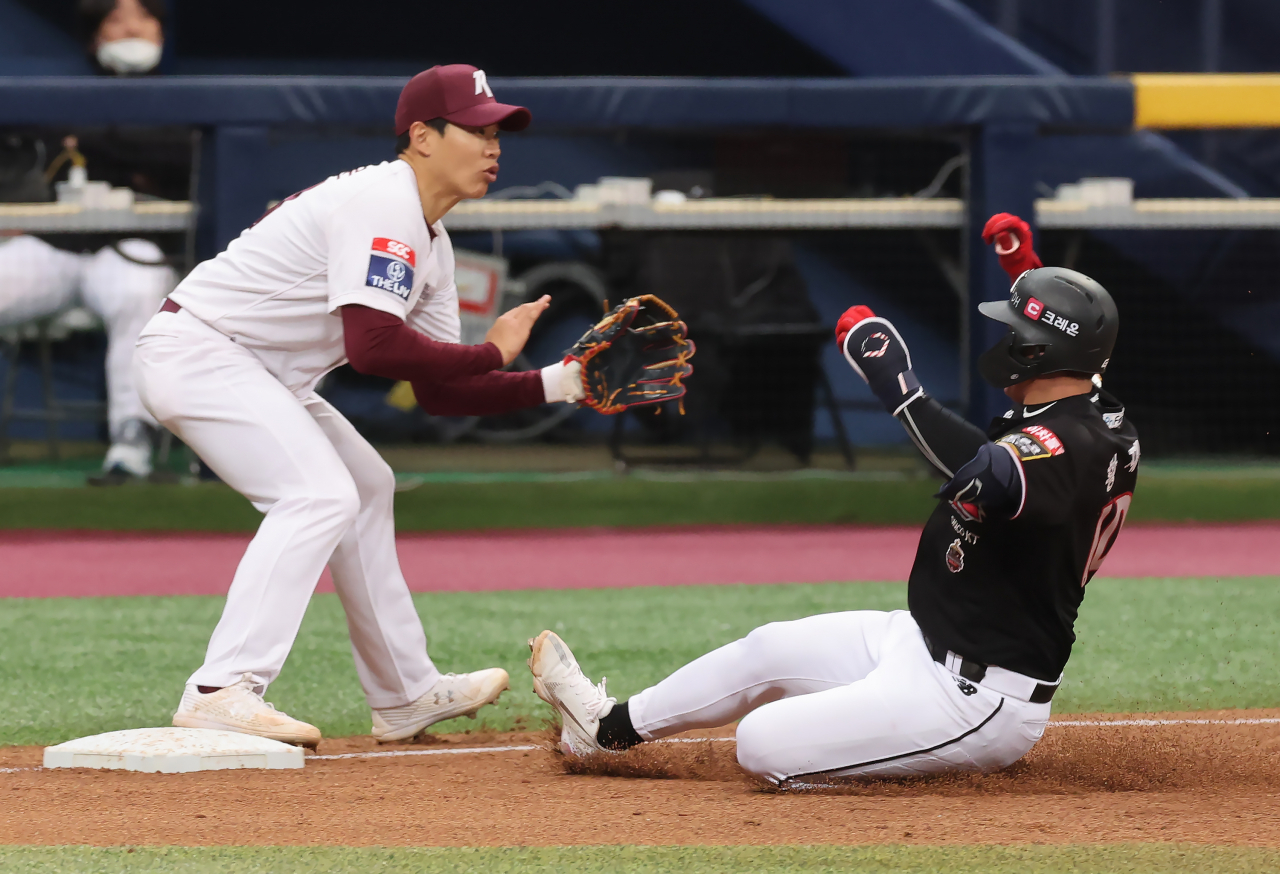 Hwang Jae-gyun of the KT Wiz (R) slides into third base after hitting a triple against the Kiwoom Heroes during the top of the fifth inning of a Korea Baseball Organization preseason game at Gocheok Sky Dome in Seoul on Tuesday. (Yonhap)