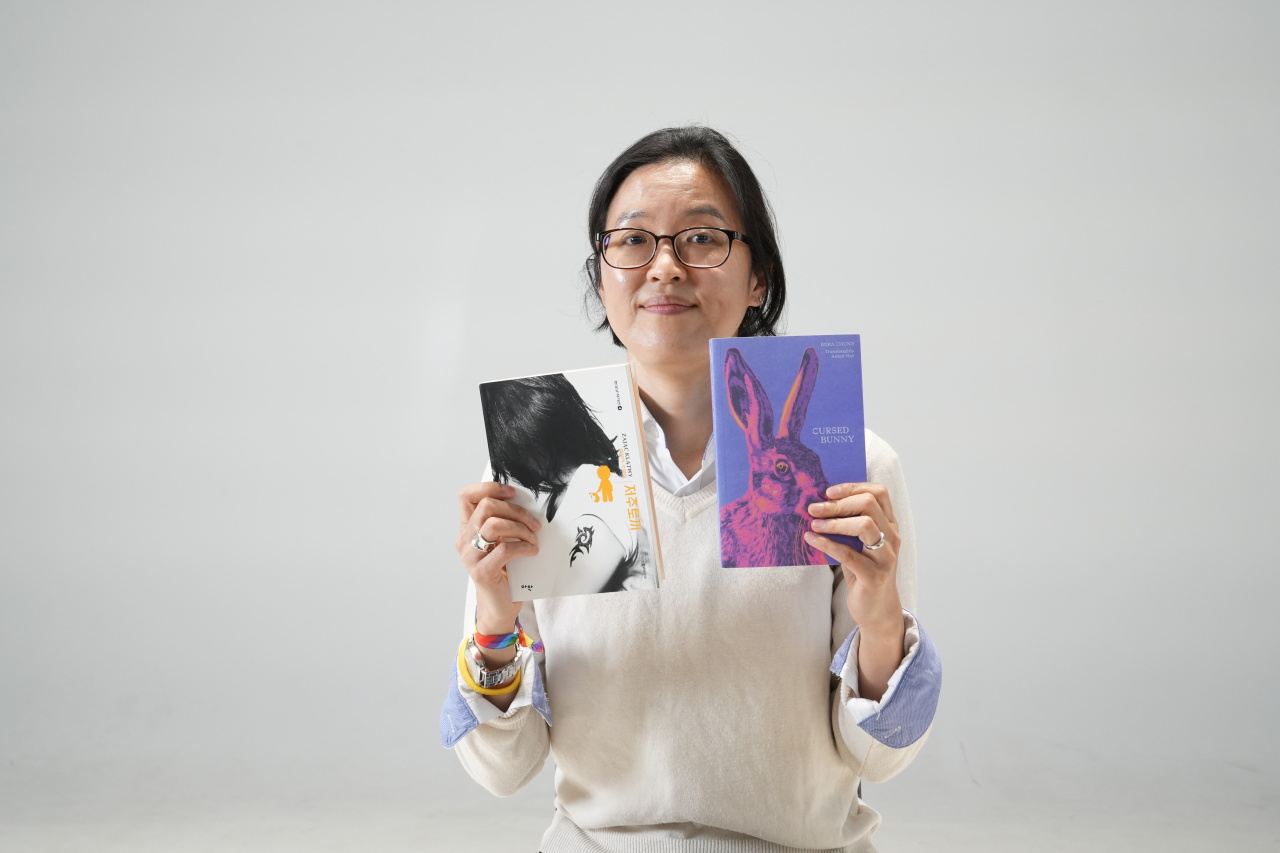Bora Chung, author “Cursed Bunny,” holds the translated book and the original Korean book. (Kim Si-yeon/The Korea Herald)