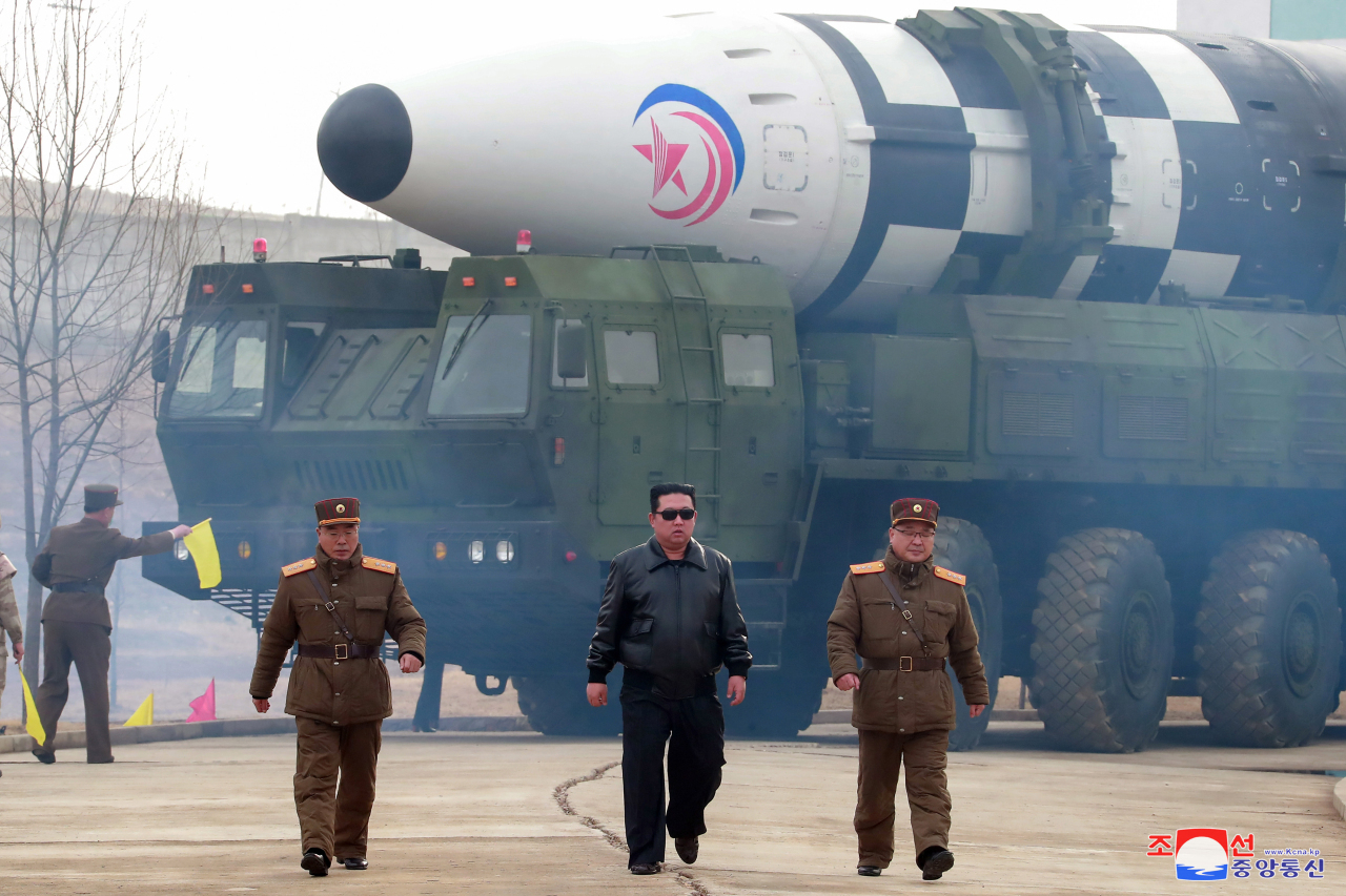 North Korean leader Kim Jong-un (center), accompanied by Jang Chang-ha (left), chief of the North`s Academy of National Defense, and Kim Jong-sik, the deputy director of the Munitions Industry Department, visits Pyongyang International Airport on Thursday to inspect the launch of a Hwasong-17 ICBM. (KCNA-Yonhap)