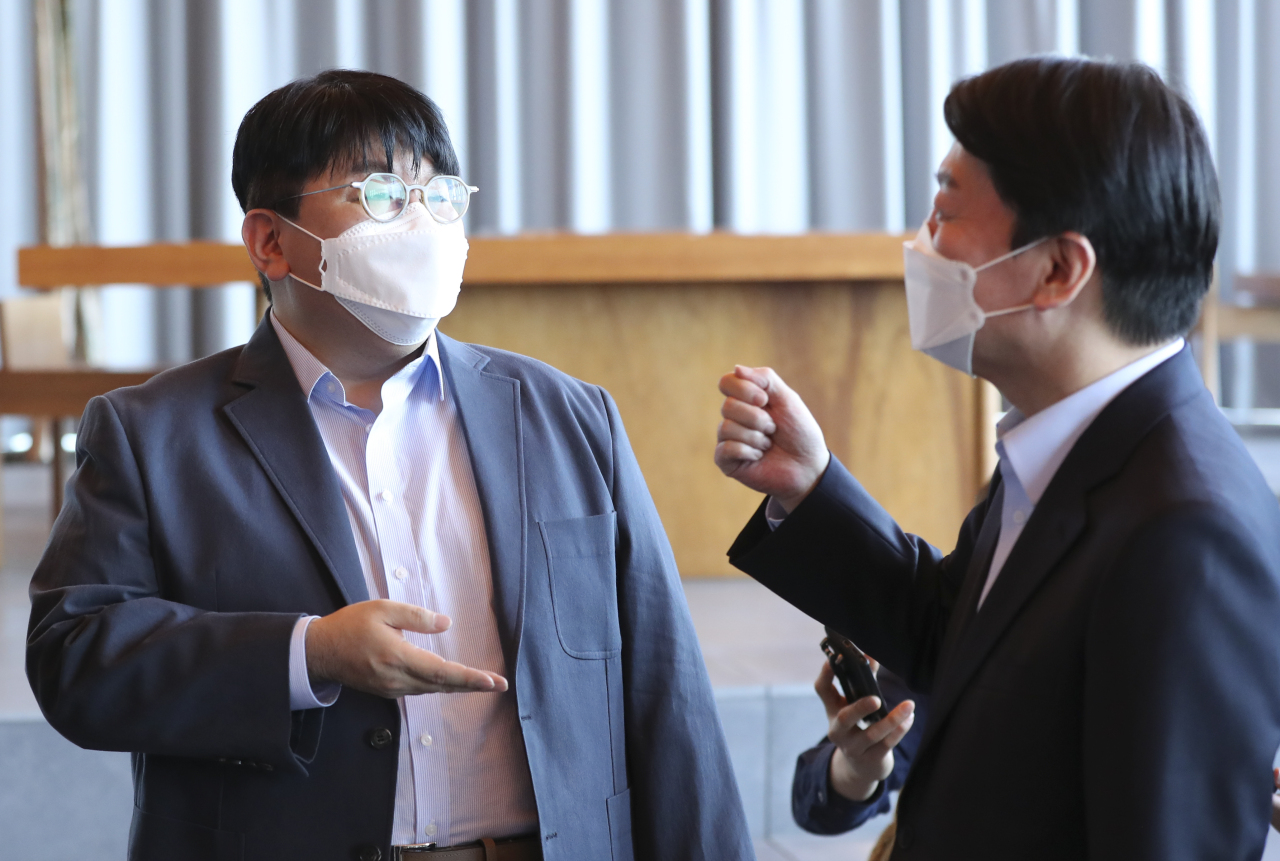 Hybe Chairman Bang Si-hyuk (left) talks with the presidential transition committee’s Chairman Ahn Cheol-soo at the company’s office in Seoul on Saturday. (Yonhap)