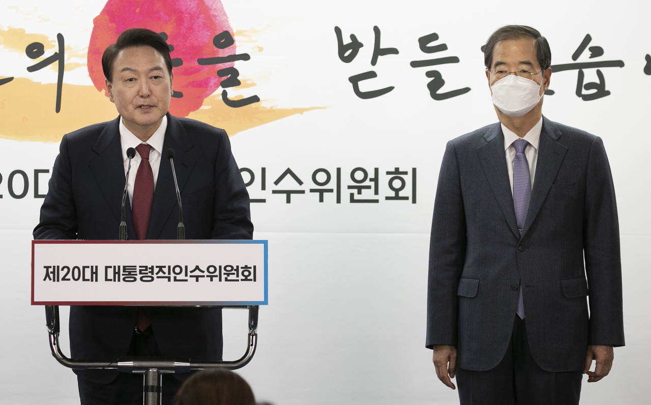 President-elect Yoon Suk-yeol (left) announces his nomination of former Prime Minister Han Duck-soo (right) as his first prime minister at his presidential transition committee's office in Seoul on Sunday. (Joint Press Corps)