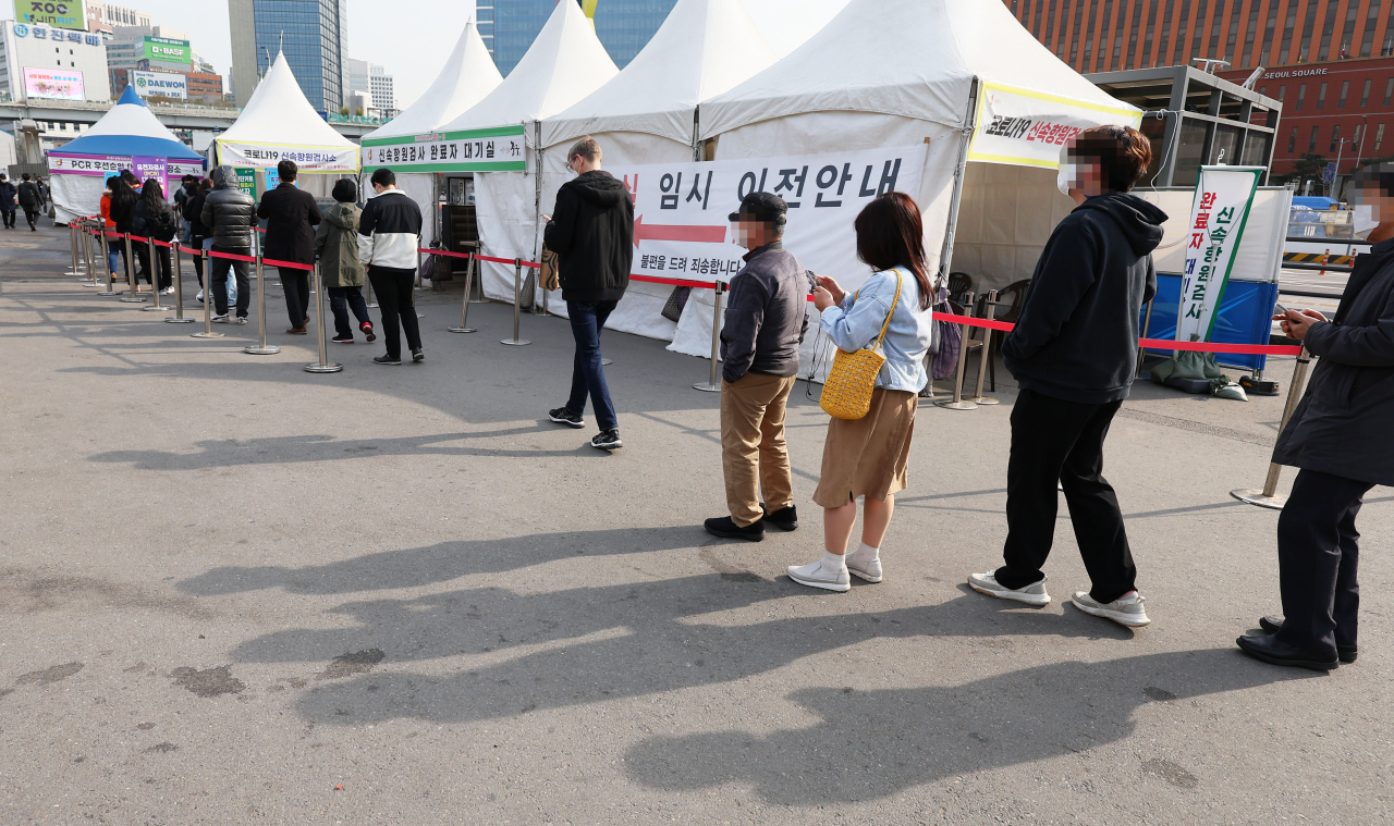 People line up to get tested for COVID-19 at a makeshift clinic on Tuesday. (Yonhap)