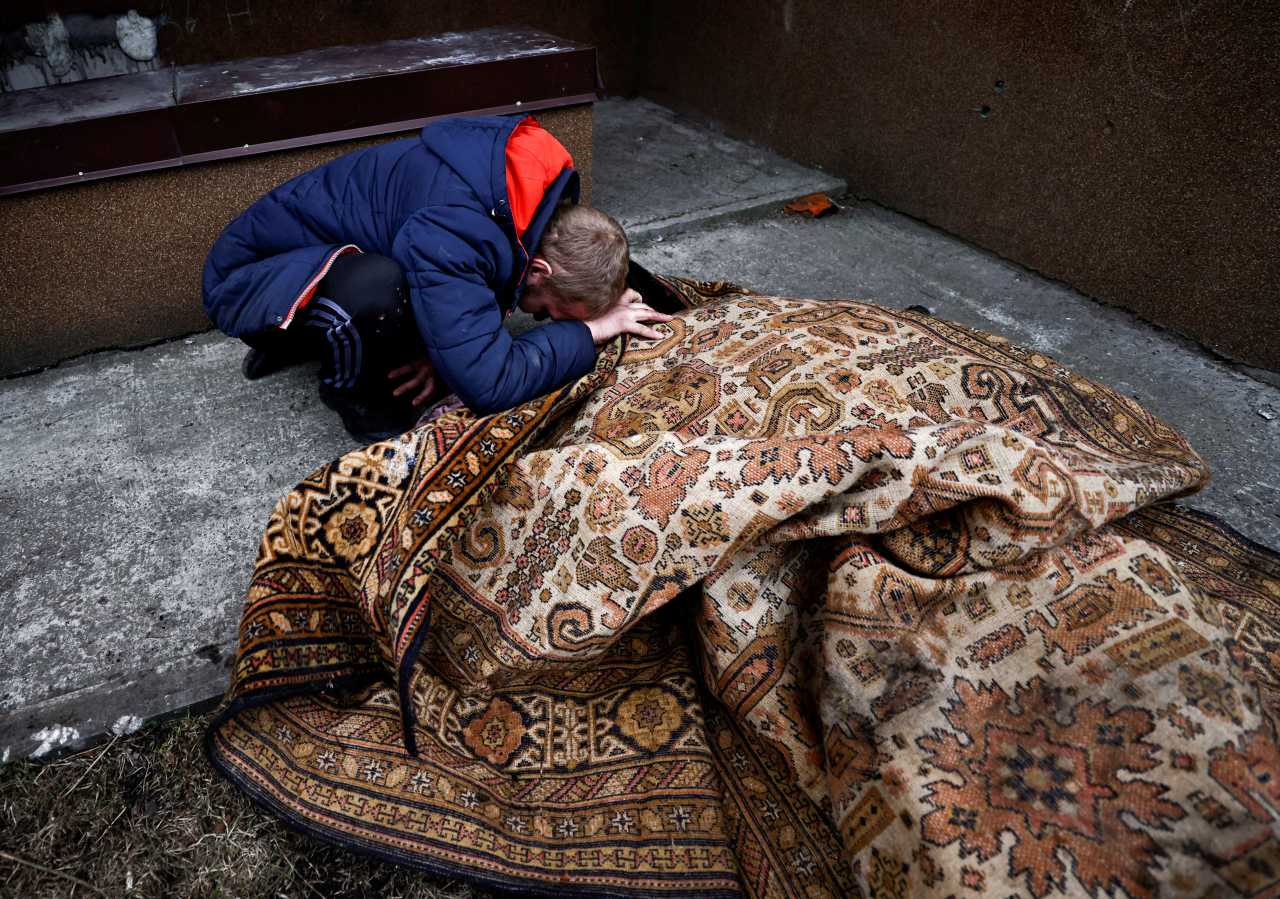 Lahovskyi, 26, mourns by the body of his friend Ihor Lytvynenko, who according to residents was killed by Russian Soldiers, after they found him beside a building's basement, amid Russia's invasion of Ukraine in Bucha, Ukraine, Tuesday. (AP)
