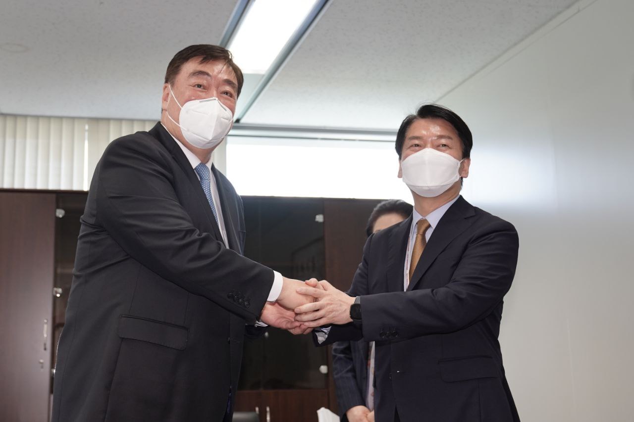 Ahn Cheol-soo, the chairman of President-elect Yoon Suk-yeol's transition committee, shakes hands with Chinese Ambassador to Seoul Xing Haiming at the committee's office in Seoul on Wednesday. (Yonhap)