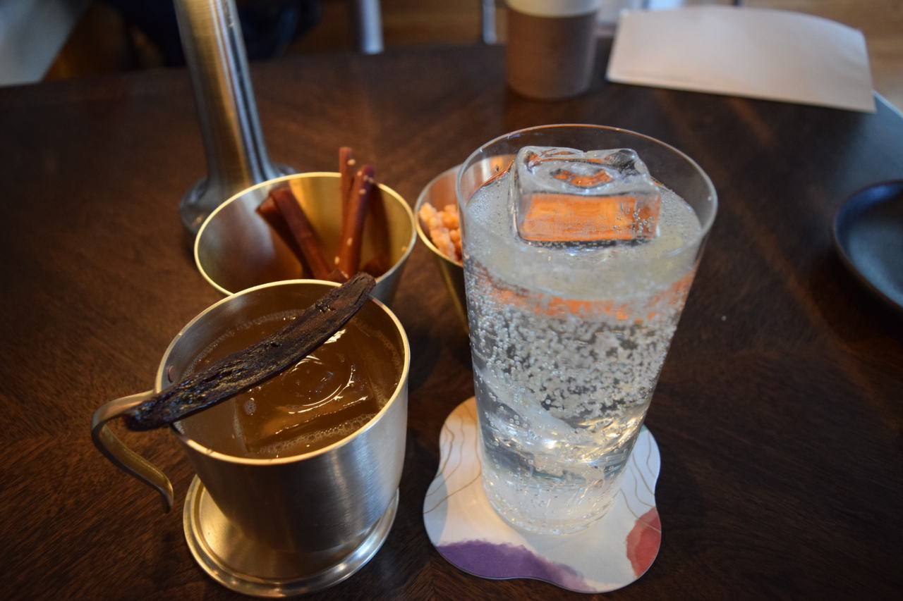 Seoul Mule (left) and Kimchi Highball with complimentary snacks are offered at Four Seasons Hotel Seoul’s Oul. (Kim Hae-yeon/The Korea Herald)