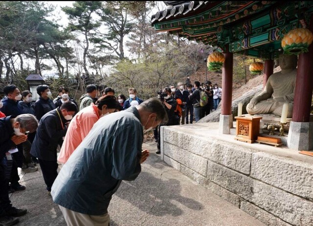 President Moon Jae-in (front) and first lady Kim Jung-sook are seen bowing in front of a Buddha statue situated behind the presidential office after completing a hike of Bukaksan on Tuesday. (Senior Presidential Secretary for Public Communication Park Soo-hyun’s Facebook)