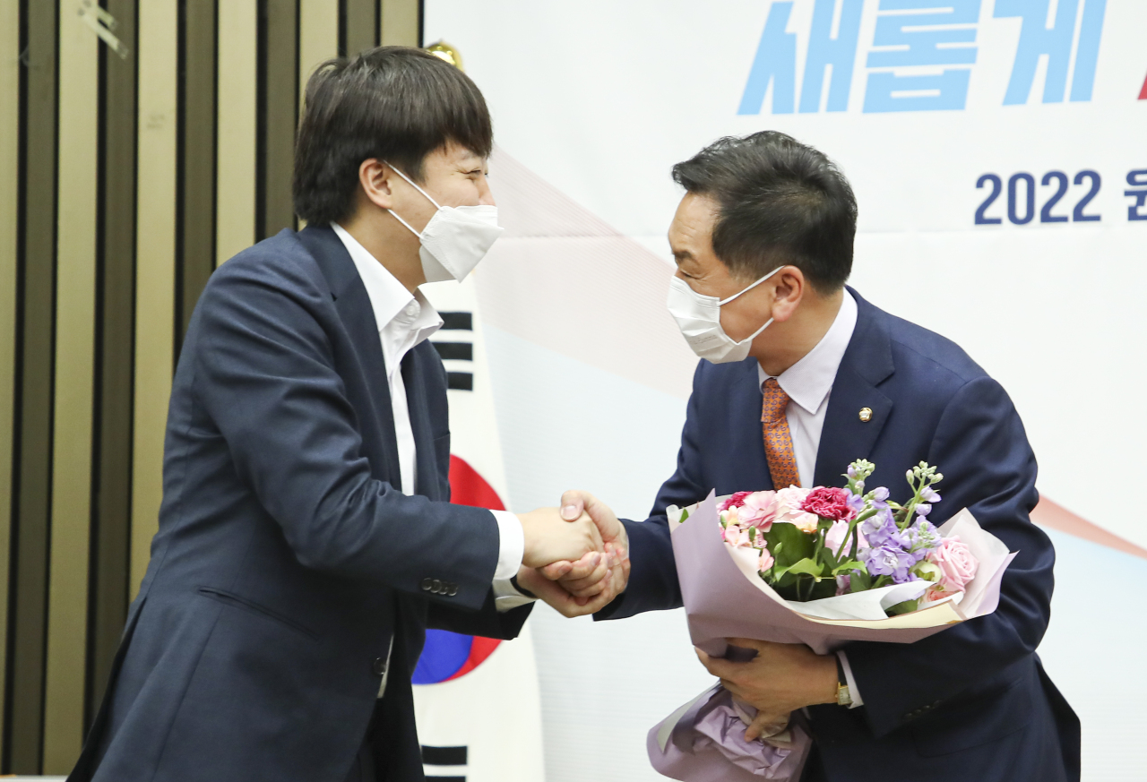 People Power Party Chairman Lee Jun-seok shakes hands with Rep. Kim Gi-hyeon, former floor leader for the conservative party, during the People Power Party`s internal election held Friday to elect its new floor leader. (Joint Press Corps)