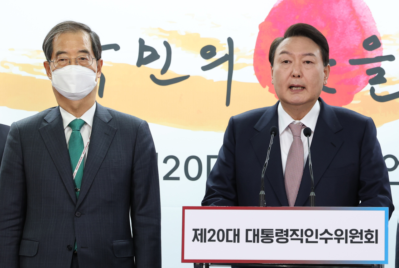 President-elect Yoon Suk-yeol (right) announces the first eight Cabinet nominees at his transition committee’s office in Seoul on Sunday. (Yonhap)