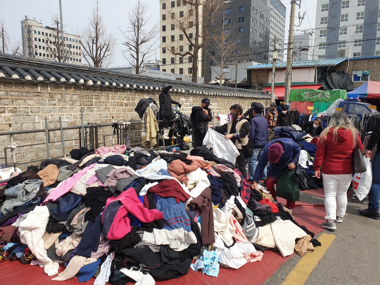 Shoppers rummage through a pile of secondhand clothes at Dongmyo Market street. (Choi Jae-hee / The Korea Herald)