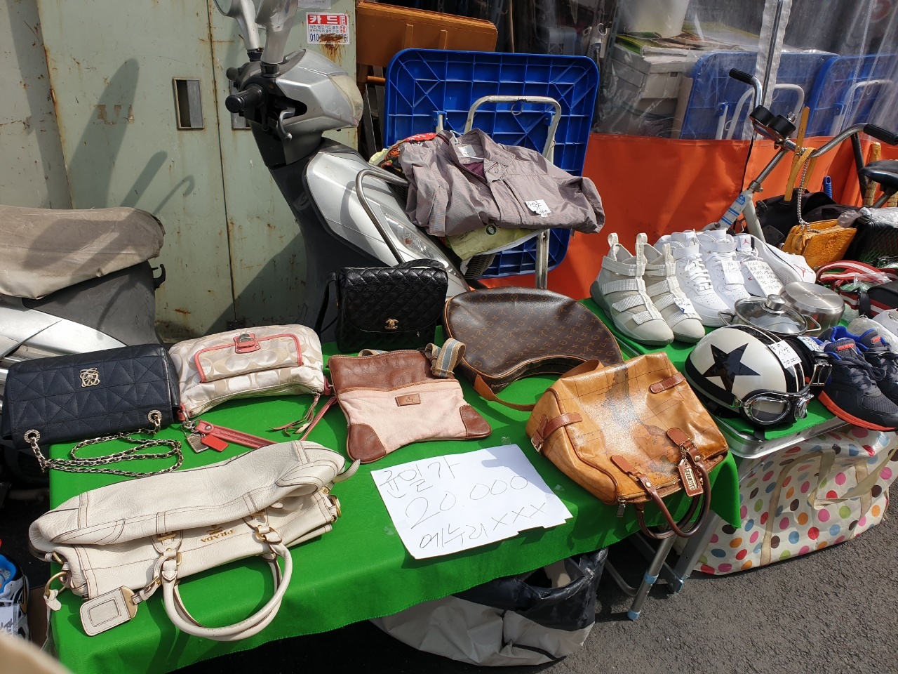 Chanel handbags and other luxury items are priced 20,000 won each at a vintage shop on the street. (Choi Jae-hee / The Korea Herald)