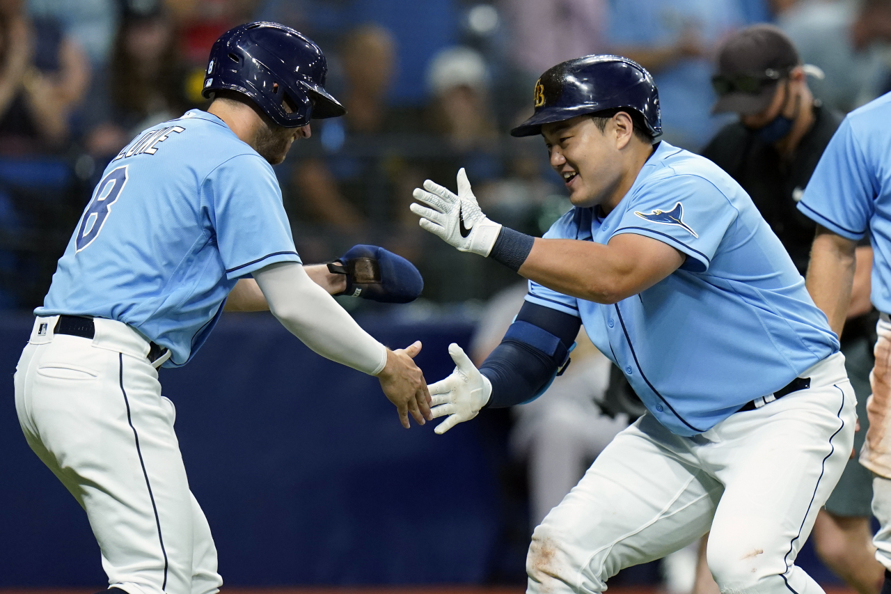 In this Associated Press photo, Choi Ji-man of the Tampa Bay Rays (R) celebrates his three-run home run off Adam Oller of the Oakland Athletics with teammate Brandon Lowe during the bottom of the second inning of a Major League Baseball regular season game at Tropicana Field in St. Petersburg, Florida, on Tuesday. (AP)