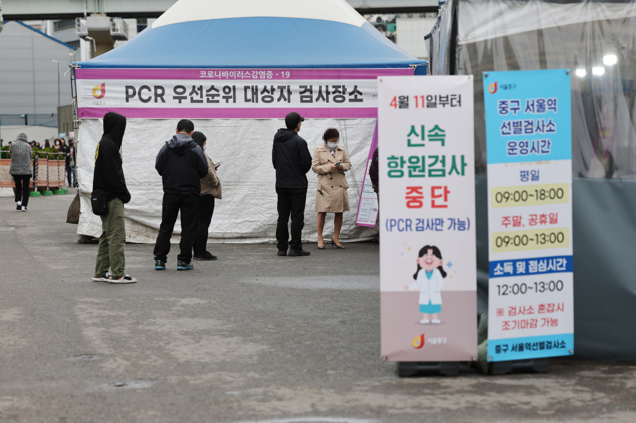 A relatively smaller number of visitors wait in line to get COVID-19 tests at a local testing station in central Seoul. (Yonhap)