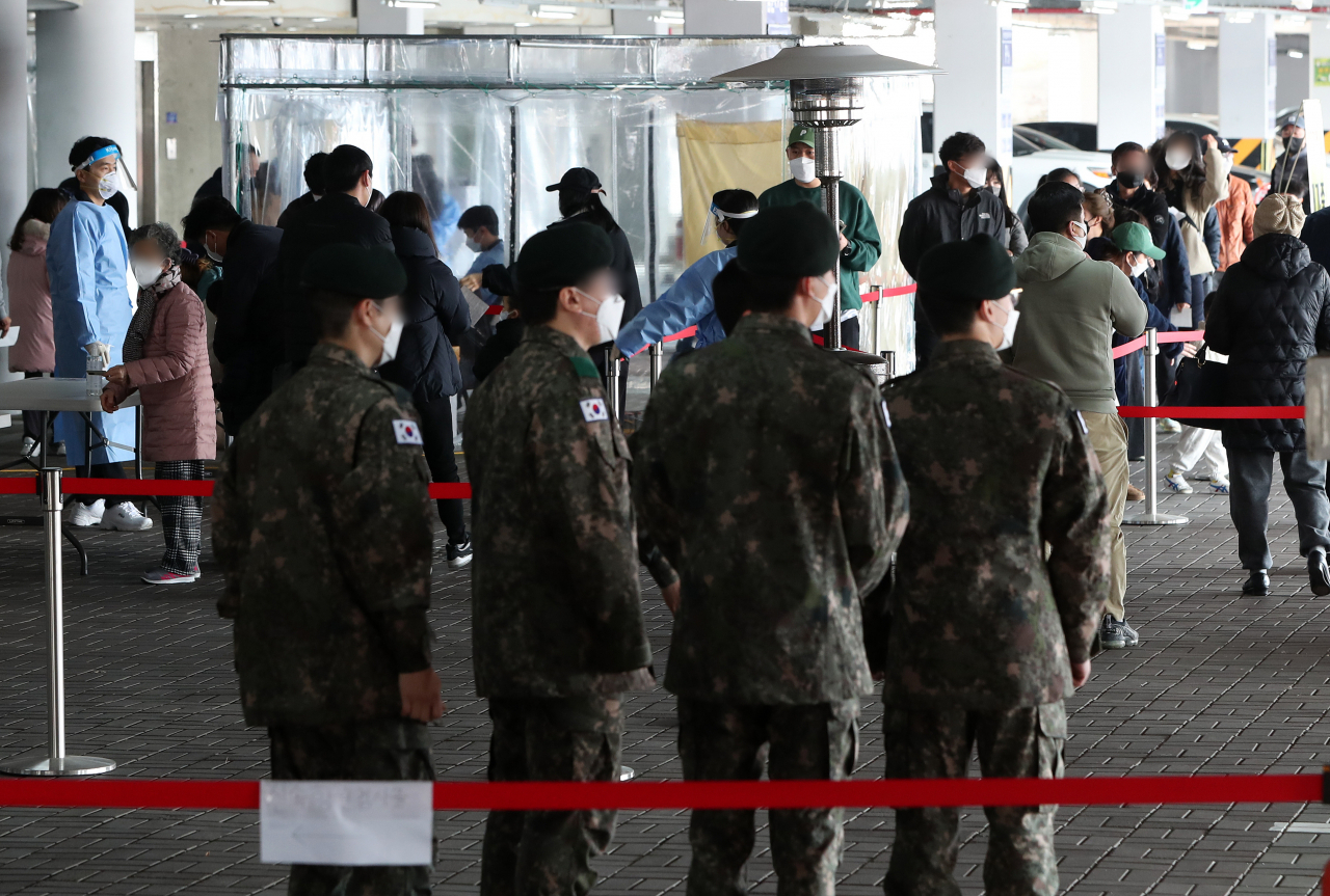 Service members wait in line to receive COVID-19 tests at a gym in Wonju, 132 kilometers southeast of Seoul, on March 22, 2022. (Yonhap)