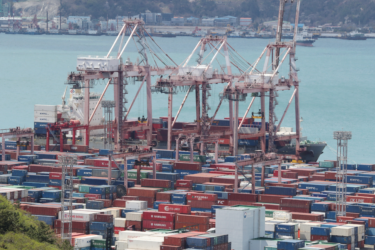 Shipping containers are moved at a port in Busan on April 1. (Yonhap)