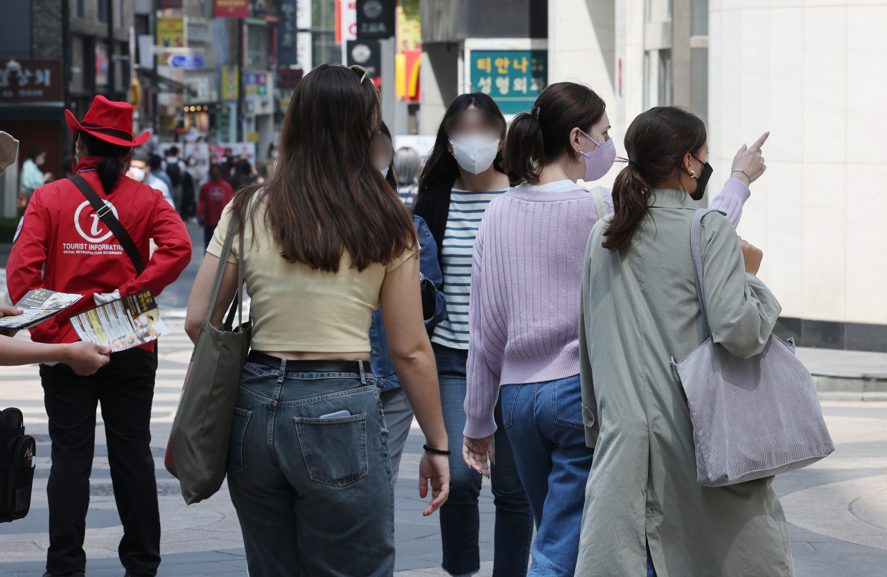 Tourists walk in the downtown shopping district of Myeongdong, Seoul, on Wednesday. (Yonhap)
