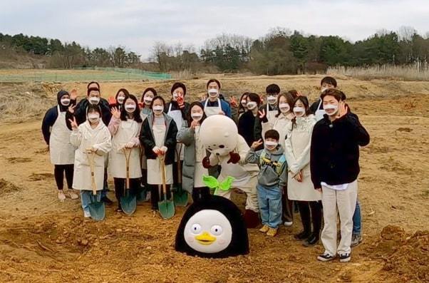 AFoCO employees pose behind EBS penguin mascot Pengsoo at one of the organization’s campaign events. (AFoCO)