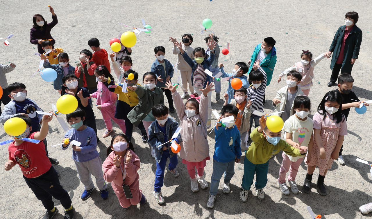 Students throw helicopter balloons in air at a science event held Wednesday at an elementary school in Suwon, Gyeonggi Province. (Joint Press Corps)