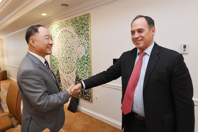 This photo, provided by the Ministry of Economy and Finance on Friday, shows South Korean Finance Minister Hong Nam-ki (L) shaking hands with Roberto Sifon-Arevalo, sovereign managing director of global credit appraiser S&P Global in Washington D.C. on Thursday before their talks. (Ministry of Economy and Finance)
