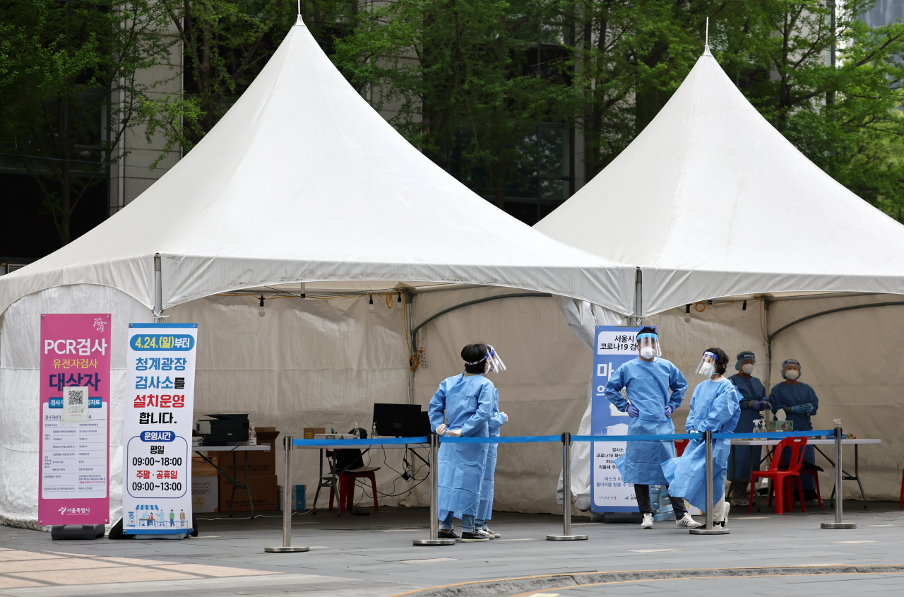 Medical workers take a rest at an empty COVID-19 testing facility in Seoul, Sunday. (Yonhap)