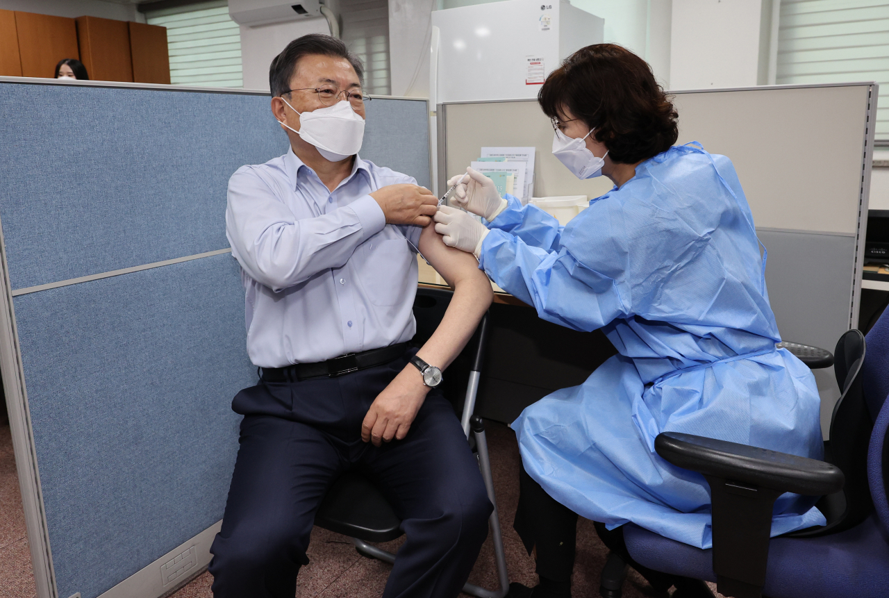 President Moon Jae-in (C) receives a second COVID-19 booster shot on Monday. (Yonhap)