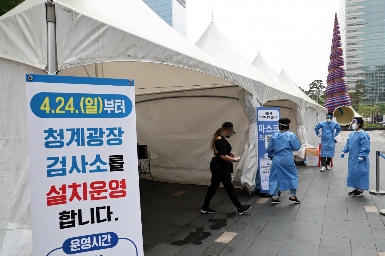 A person waits at a makeshift clinic in central Seoul on Sunday, to get tested for COVID-19. (Yonhap)